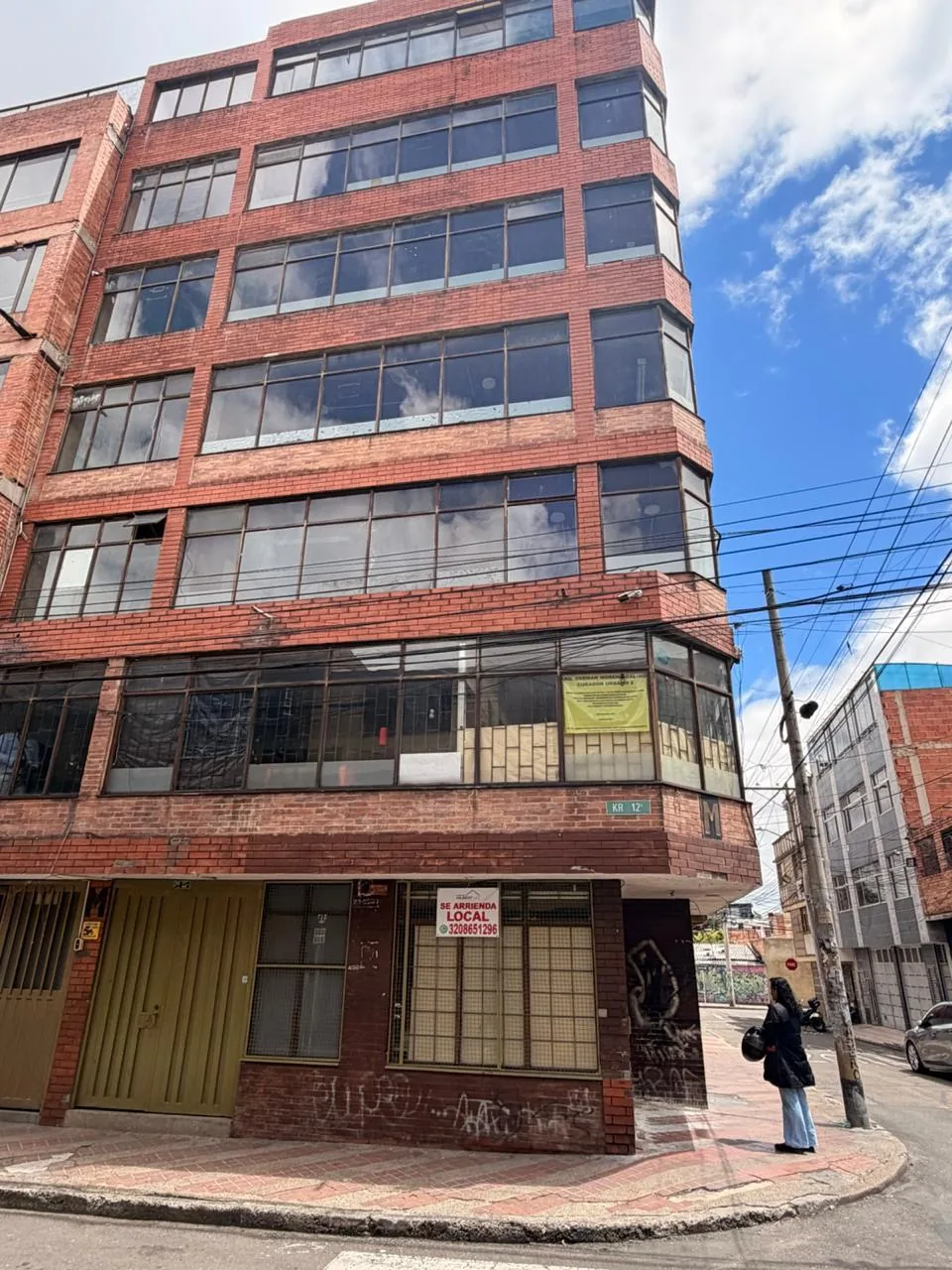 Fachada en esquina con ventanas amplias y contexto urbano